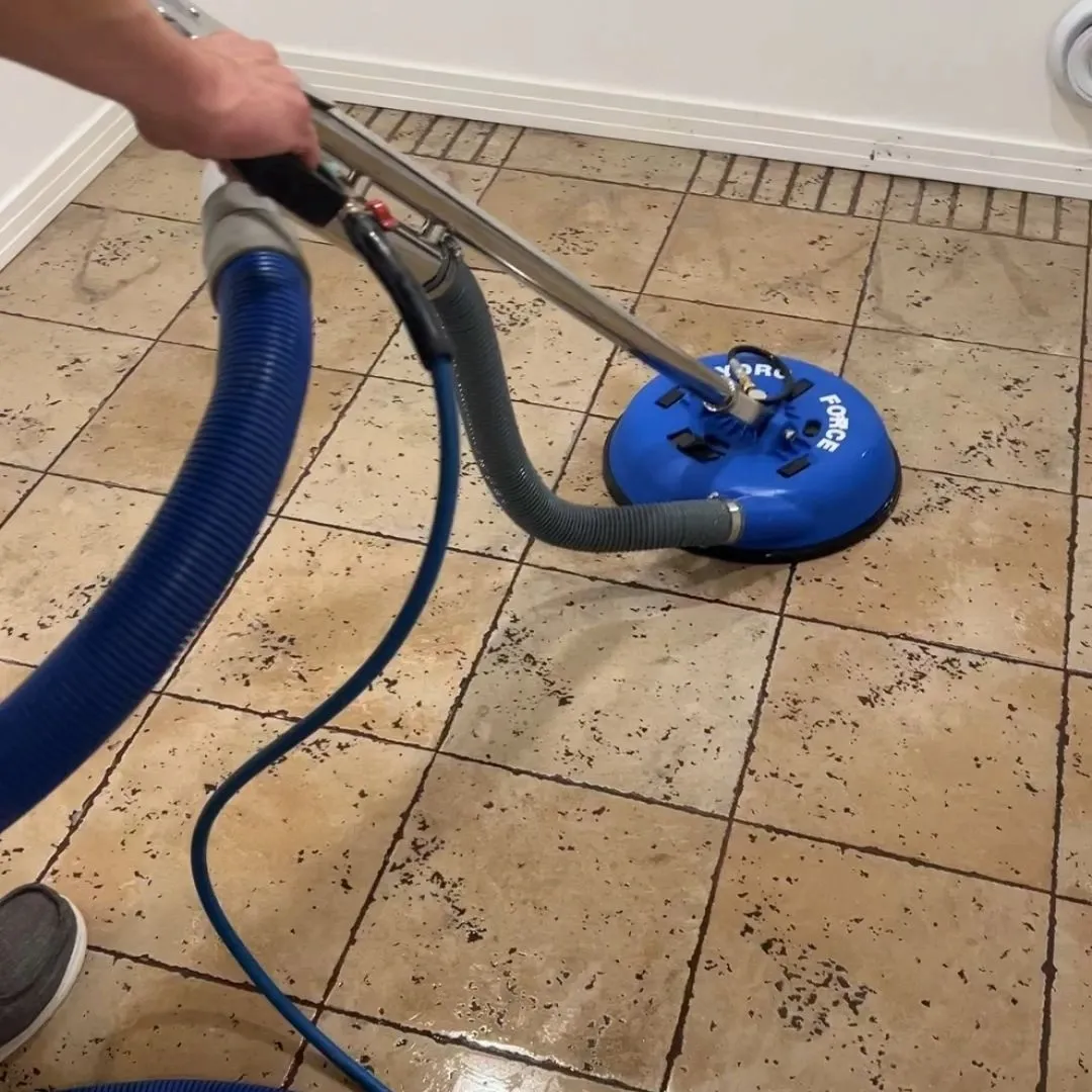 Tile and grout cleaning in Saskatoon showing dirty beige floor tile beside a freshly cleaned section Tile and grout cleaning in Saskatoon showing dirty beige floor tile beside a freshly cleaned section